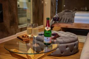 吉夫霍恩exkl. romantisches SM Apartment Black Rose的玻璃桌旁的一瓶香槟和两杯酒