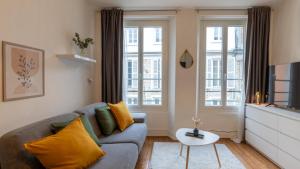 枫丹白露Cœur de Fontainebleau: Confort, Calme & Haut débit的带沙发和2扇窗户的客厅