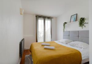 贝宗Le CENTRE VILLE de Bezons的一间卧室配有一张大床和两条毛巾