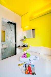 新加坡Fragrance Hotel - Classic的一间卧室设有黄色的墙壁和一张带杂志的床