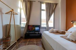 纳弗帕克托斯Lepanto Xenia Apartments 1F的一间卧室设有一张床、一台电视和窗户。