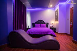 绥和市Hoàng Gia Hotel Tuy Hoà的紫色卧室,配有一张带紫色床罩的床