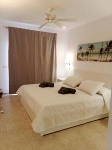 阿罗纳CASA PARAISO的卧室配有一张带两个枕头的大白色床