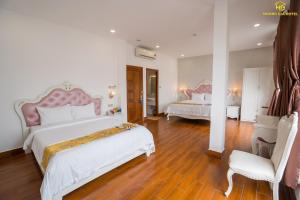 绥和市Hoàng Gia Hotel Tuy Hoà的一间大卧室,配有两张床和椅子