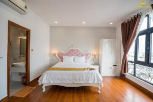 绥和市Hoàng Gia Hotel Tuy Hoà的卧室配有白色床和粉红色床头板