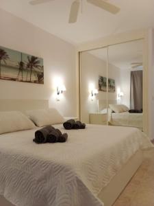 阿罗纳CASA PARAISO的卧室配有一张带镜子的白色大床