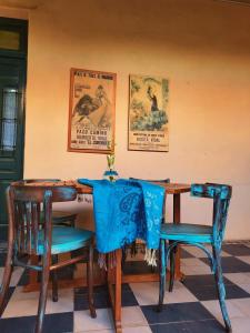 图蓬加托火山Casa Vidal Guesthouse的一张桌子、蓝色的椅子和墙上的海报
