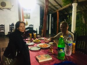明内里耶Randiya Holiday Resort的坐在餐桌旁吃饭的男人和女人