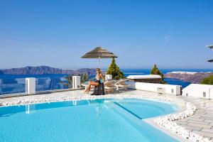 易莫洛林Santorini Princess Spa Hotel的坐在游泳池旁椅子上的女人