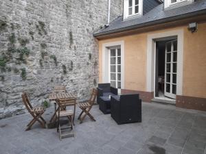 卢森堡Superbe logement à proximité du centre et du Kirchberg的一个带桌椅的庭院和一座建筑