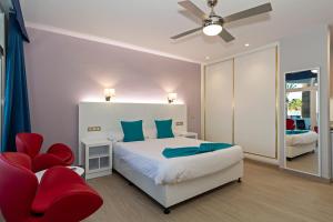 卡门港全景公寓酒店 - 仅限成人入住的一间卧室配有一张床和一张红色椅子