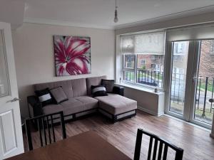 HornchurchCosy Spacious 2 bed flat Hornchurch high street的客厅配有沙发和桌子