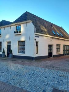 OudewaterDe Kapelle in Oudewater的白色的建筑,有黑色的屋顶和窗户