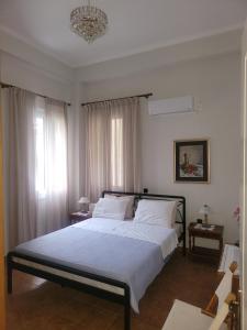 帕莱罗斯Palairos historic property的一间卧室配有一张带白色床单和吊灯的床。