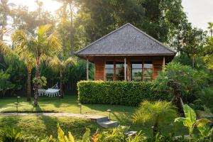 卡朗阿森East Bali Volcano View Resort & Spa - Adults Only Area的花园内带长凳的木制凉亭