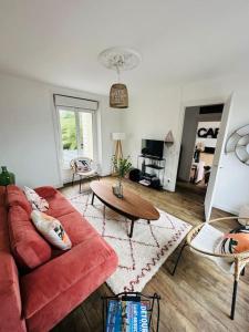 圣布里厄La dolce Vita/maison/5km plages的客厅配有红色的沙发和桌子