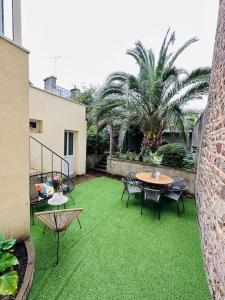 圣布里厄La dolce Vita/maison/5km plages的一个带绿草和桌椅的庭院