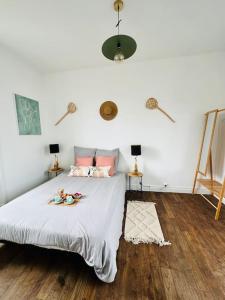 圣布里厄La dolce Vita/maison/5km plages的一间卧室配有一张铺有木地板的白色床单。