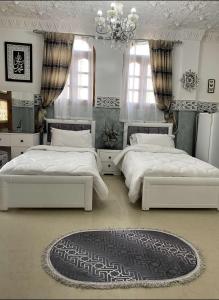 La rose des sables的一间卧室配有两张床和吊灯。