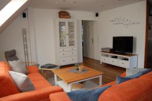费马恩Ferienwohnung Oberdeck的客厅配有橙色沙发和桌子