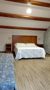 布埃乌托雷城乡村民宿的一间卧室配有一张大床和木制床头板