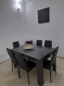 达喀尔Cosy F3 au point E的黑色餐桌和黑色椅子
