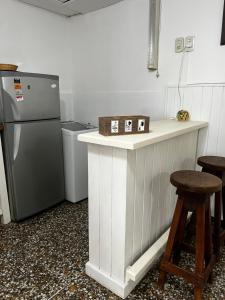 圣罗莎Dpto Beltrán的厨房配有冰箱和带凳子的台面