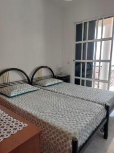 Madalena do MarBarbara Home的一间卧室设有两张床和窗户。