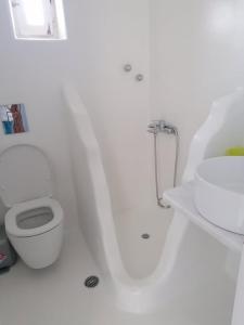圣斯特凡诺斯Mykonos Rooms的白色的浴室设有卫生间和水槽。