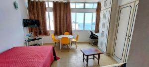 圣维森特岛Apto vista Privilegiada da Praia的卧室配有一张床和一张桌子及椅子