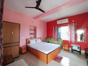 博尔普尔Muktomon Hotel & Resort的一间卧室设有一张床和红色的墙壁