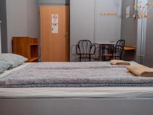 布达佩斯迪普旅舍的一张位于带椅子和桌子的房间的床铺