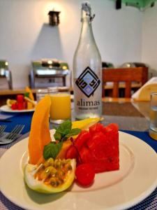 费利杜Alimas Holiday Retreat Maldives的桌上的水果盘和一瓶