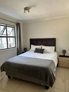 开普敦Cozy Rondebosch Apartment的一间卧室设有一张大床和一个窗户。