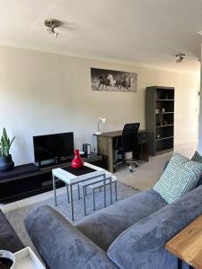 开普敦Cozy Rondebosch Apartment的客厅配有沙发和桌子