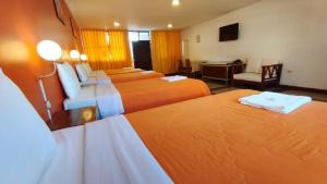 阿亚库乔Hotel Yañez Inn的酒店客房设有四张床和书桌