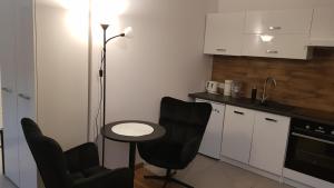 新松奇Komfortowy apartament w centrum Nowego Sącza的厨房配有两把椅子、一张桌子和一盏灯