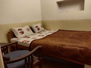 阿杰梅尔Natraj Guest House的小房间设有一张床和一把椅子