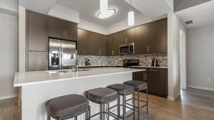 Fort Myers VillasLanding Modern Apartment with Amazing Amenities (ID8608X81)的厨房配有木制橱柜和酒吧凳子