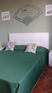 马尔扎梅米Villa Milena的一张绿色的床,上面有两个枕头