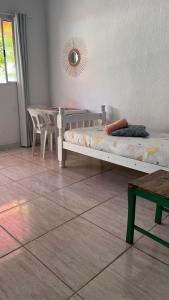 瓜鲁雅Pousada Suítes Sete Mares的卧室配有一张床和一张桌子