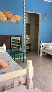 瓜鲁雅Pousada Suítes Sete Mares的配有床、椅子和镜子的房间