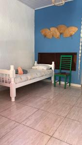 瓜鲁雅Pousada Suítes Sete Mares的一间卧室配有一张床和一把绿色椅子