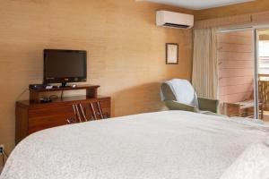 基黑Lotus Suite in a Boutique Resort, 1Bedroom Sleeps 4的一间卧室配有一张床和一台平面电视