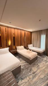 麦加فندق ماسة المشاعر الفندقية的酒店客房,设有三张床和木墙