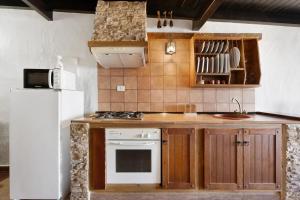 莫卡诺尔Apartamentos Trebol的厨房配有炉灶和白色冰箱。