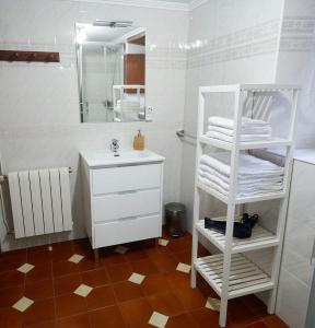 纳维亚Casa Choureiro Apartamentos Rurales的浴室设有白色水槽和带毛巾的白色架子。