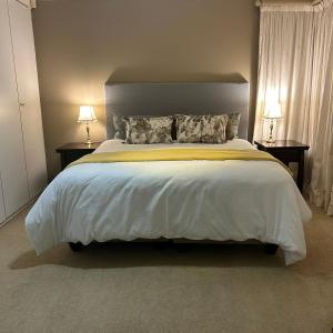 比勒陀利亚741 Tetra Self Catering Accommodation的一间卧室配有一张带两盏灯的大型白色床。