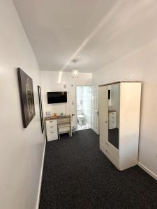 剑桥Newmarket Road Studios and Suites By Tas Accommodations的客房设有冰箱和书桌。
