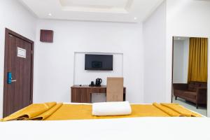 莱基LA FIFTHIN VILLA的一间卧室配有一张床、一台电视和一张沙发